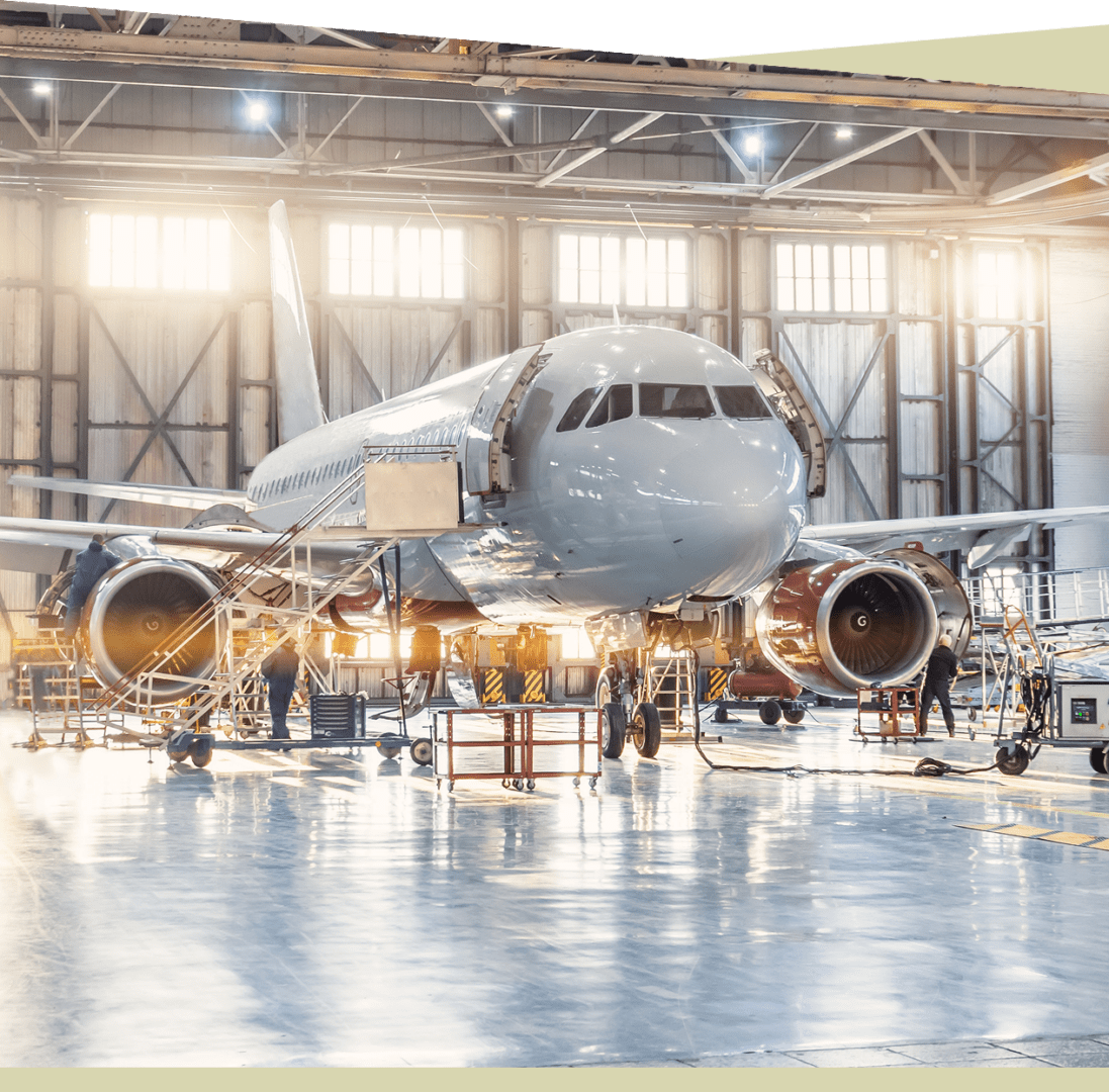 Group 8 A passenger airplane is undergoing maintenance in a well-lit, spacious hangar, surrounded by equipment and machinery. Skilled technicians, adhering to mechanic certification criteria, work meticulously to ensure every detail meets high safety standards.