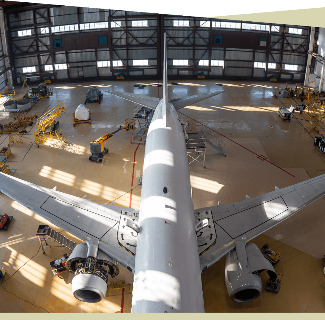Group 9 Viewed from above, the airplane rests in the hangar surrounded by maintenance equipment and platforms, as technicians go through mechanic certification criteria to ensure every detail meets the highest standards.